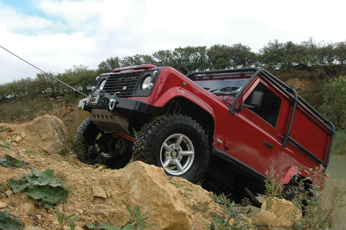 Red Land Rover winching up a hill