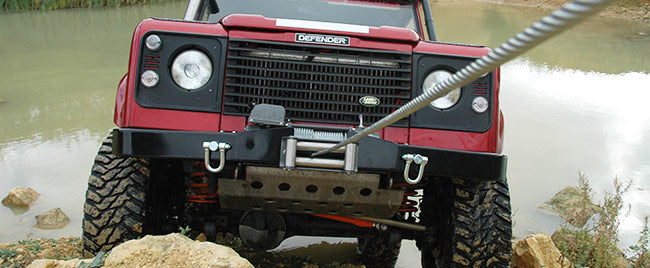 Red Land Rover winching up a hill