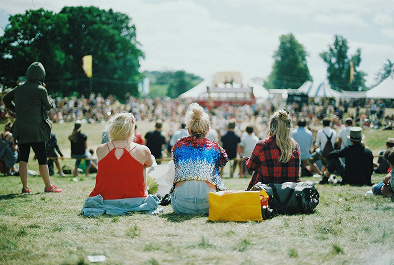 Girls sitting at an outdoor festival